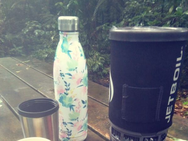 Picture of a Jet Boil pesonal stove and travel mugs on a picnic table